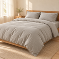 Parure de lit Palette gris perle dans une chambre aux tons naturels — mise en scène générée par IA.